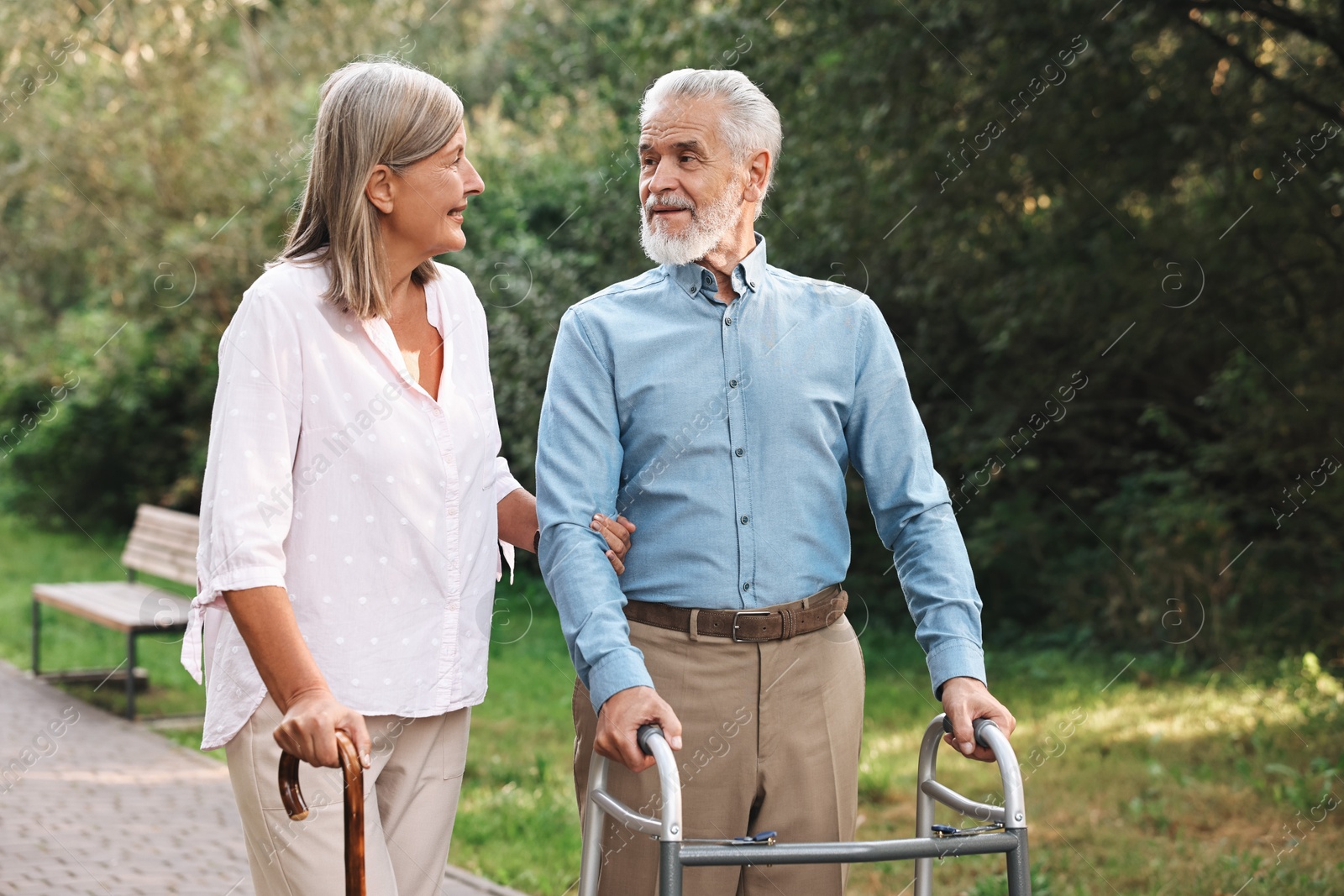 Photo of Senior couple with walking frame and cane in park