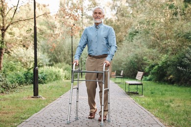 Photo of Senior man with walking frame in park