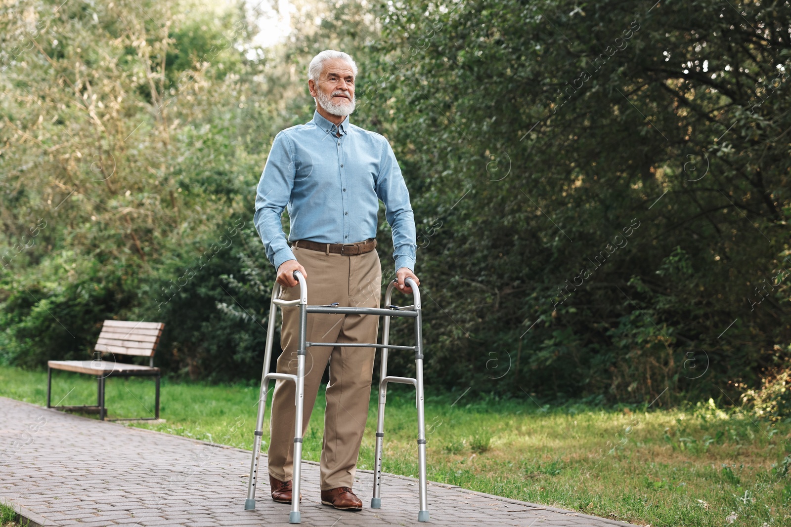 Photo of Senior man with walking frame in park