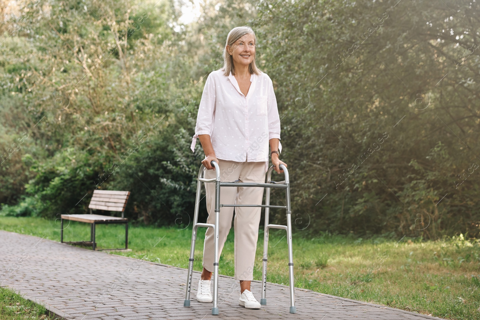 Photo of Senior woman with walking frame in park