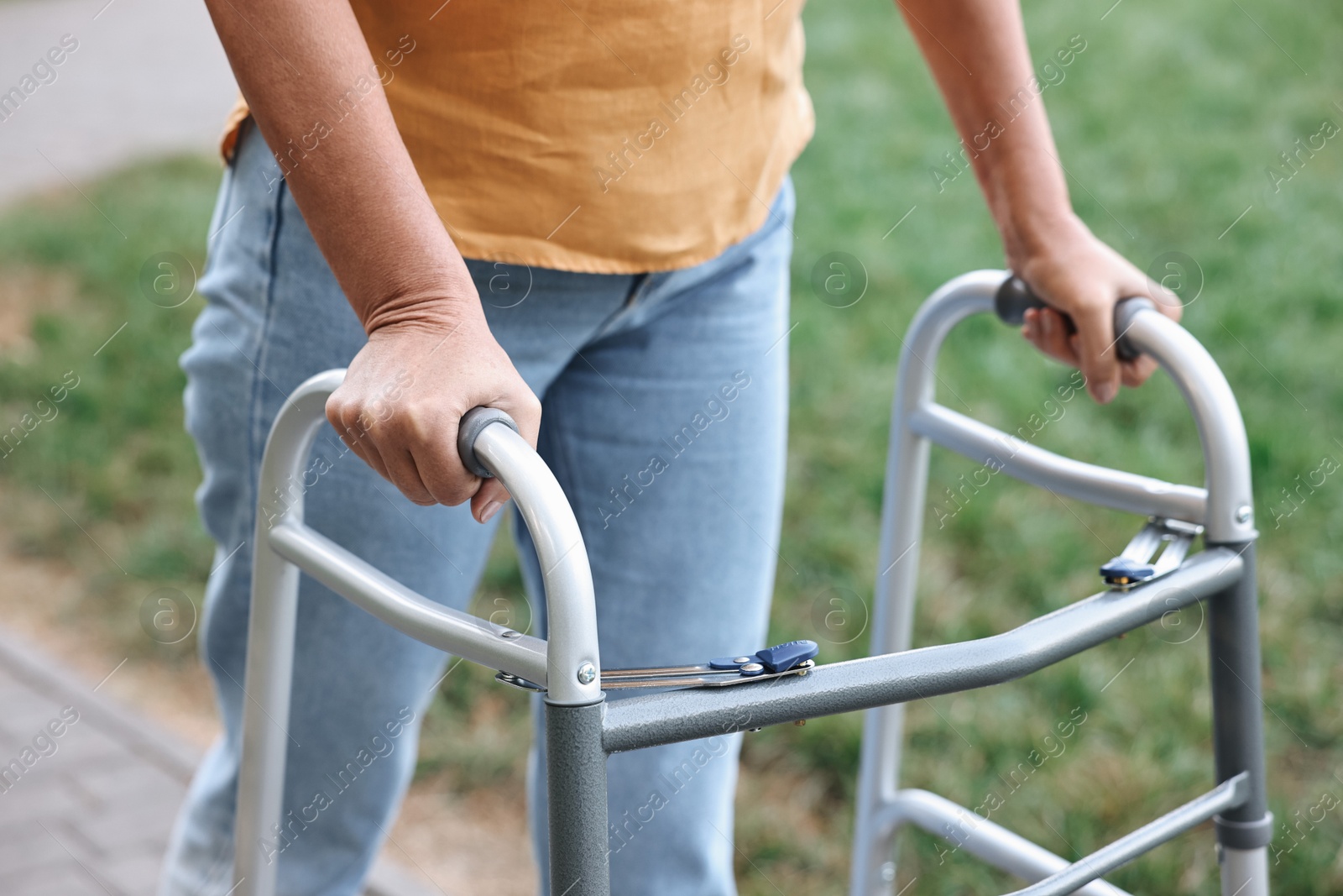 Photo of Senior woman with walking frame in park, closeup