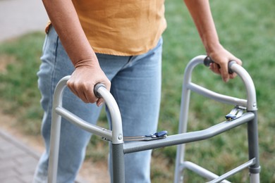 Photo of Senior woman with walking frame in park, closeup