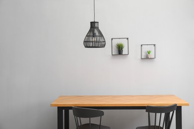 Photo of Wooden table with black chairs in stylish dining room