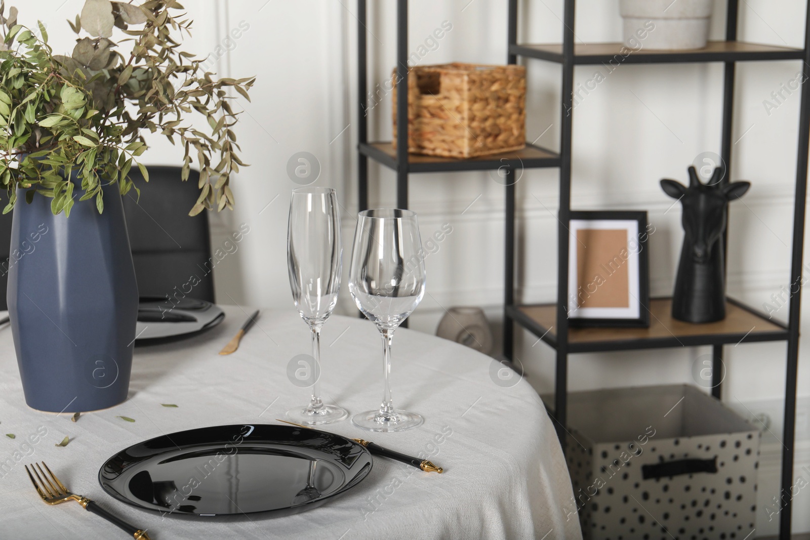 Photo of Stylish table setting with black dishware in dining room