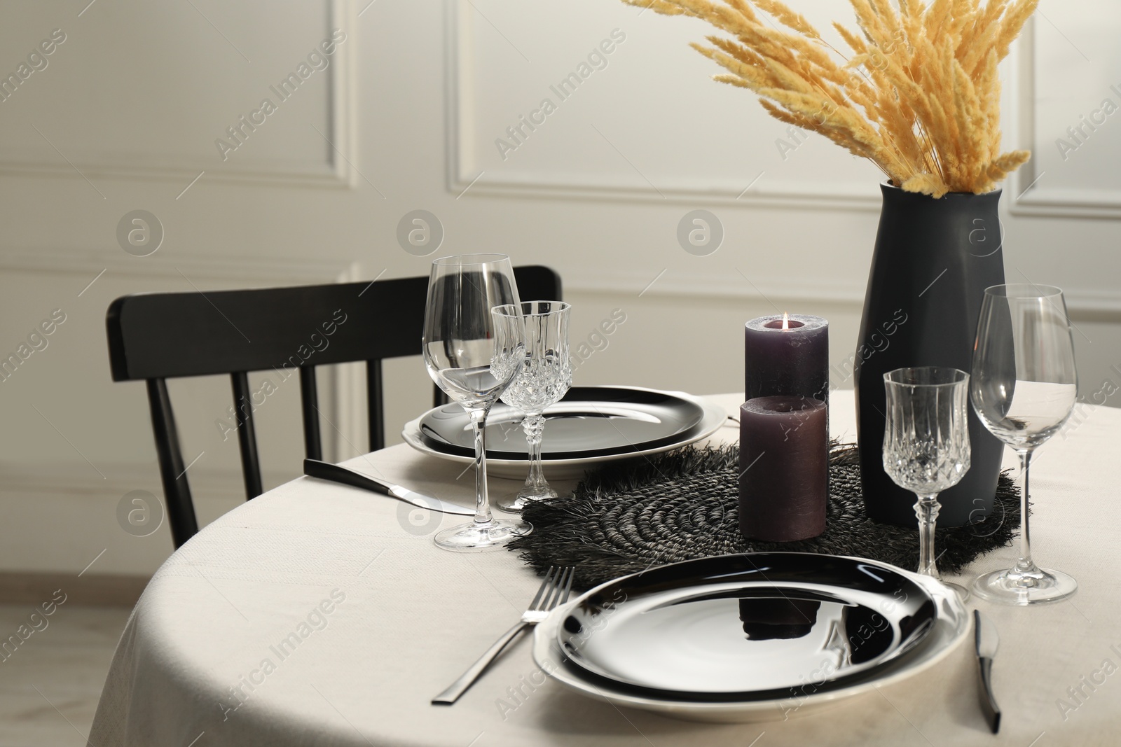 Photo of Stylish table setting with black dishware in dining room