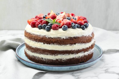 Photo of Delicious chocolate sponge cake with berries on white table, closeup