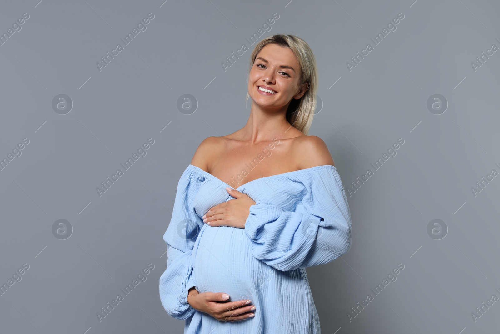 Photo of Portrait of beautiful pregnant woman on grey background