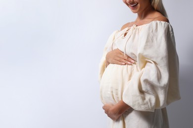 Photo of Pregnant woman on white background, closeup. Space for text