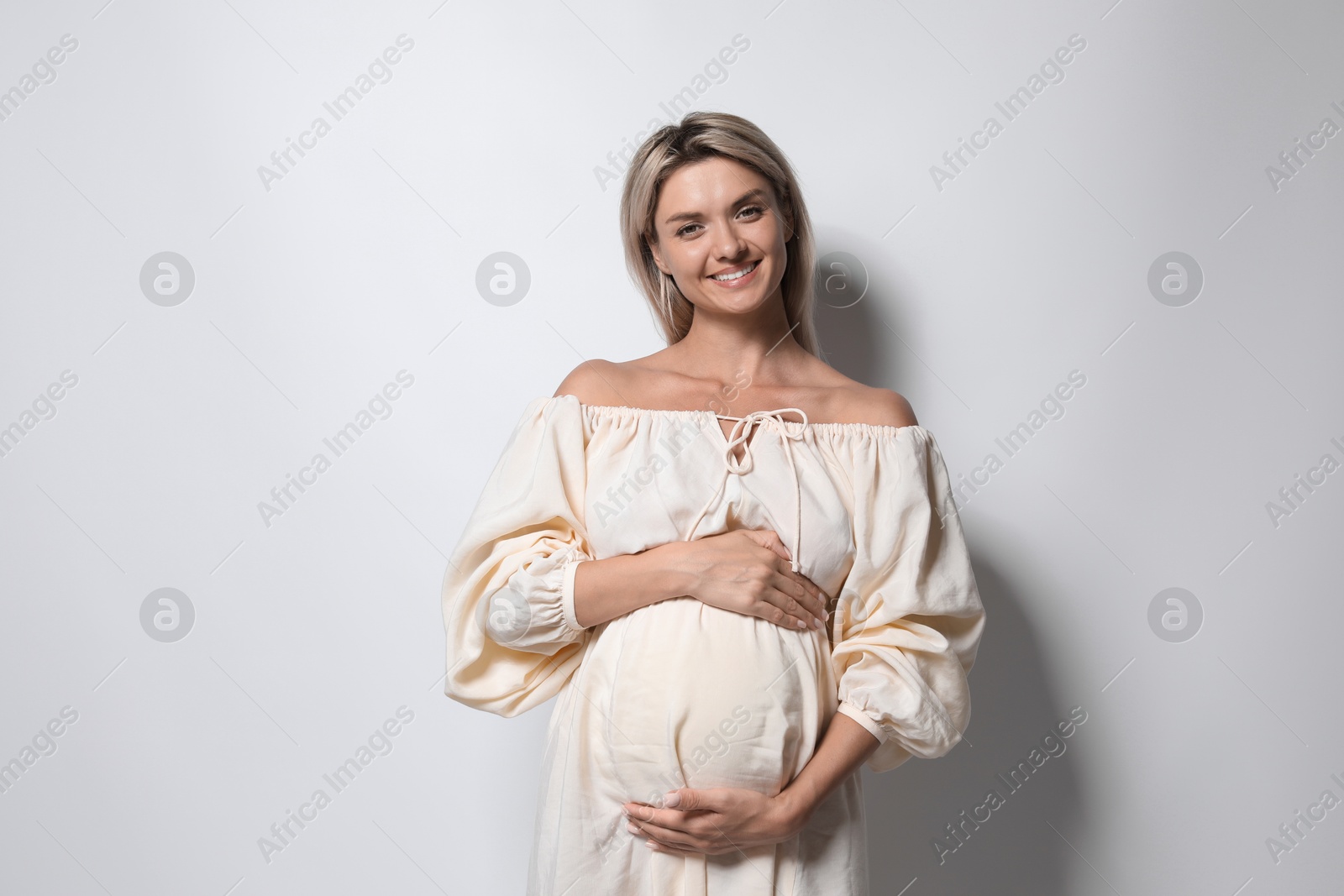 Photo of Portrait of beautiful pregnant woman on white background