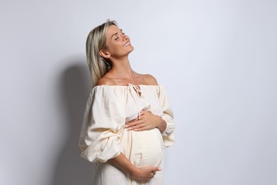 Portrait of beautiful pregnant woman on white background