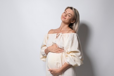 Photo of Portrait of beautiful pregnant woman on white background