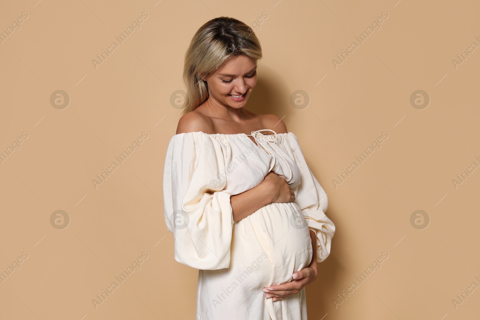 Photo of Portrait of beautiful pregnant woman on beige background