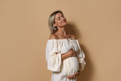 Photo of Portrait of beautiful pregnant woman on beige background