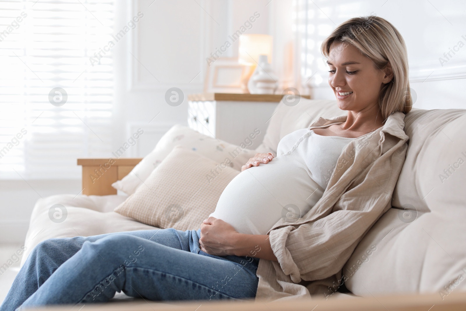 Photo of Portrait of beautiful pregnant woman on sofa at home