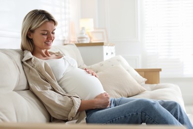 Photo of Portrait of beautiful pregnant woman on sofa at home