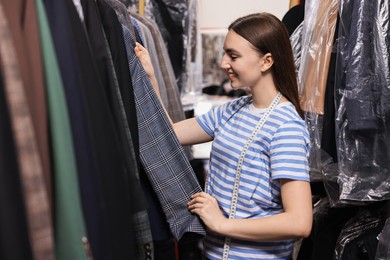 Photo of Stylish atelier. Young woman working in professional workshop