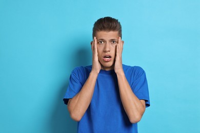 Photo of Emotional student having stress before exam on light blue background