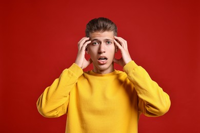 Photo of Emotional student having stress before exam on red background