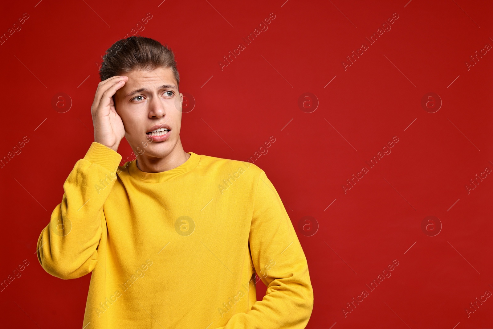 Photo of Emotional student having stress before exam on red background. Space for text