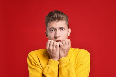 Photo of Emotional student having stress before exam on red background