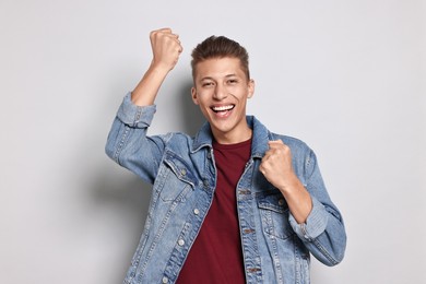 Photo of Student feeling happy about his good exam result on grey background