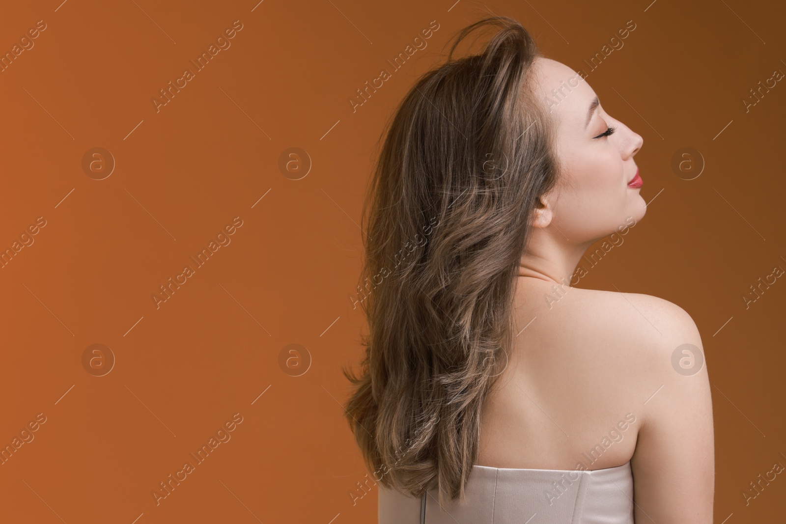 Photo of Attractive woman with stylish haircut on brown background, space for text