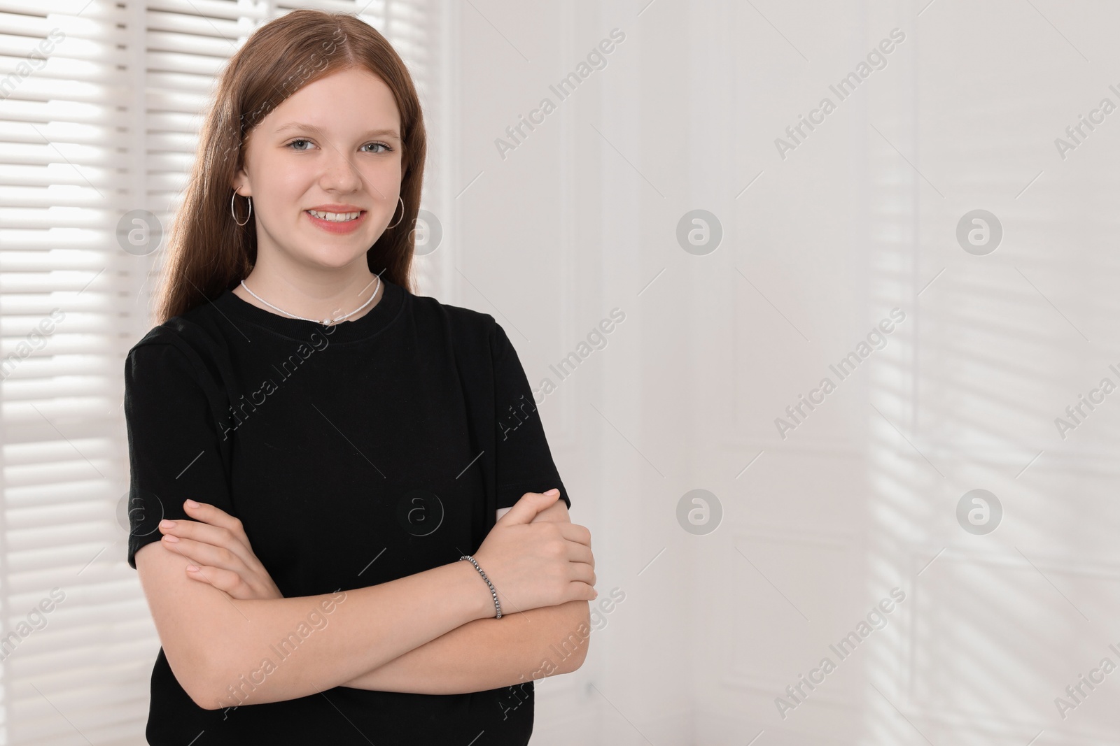 Photo of Portrait of happy teenage girl at home, space for text