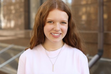 Photo of Portrait of happy teenage girl with long hair outdoors