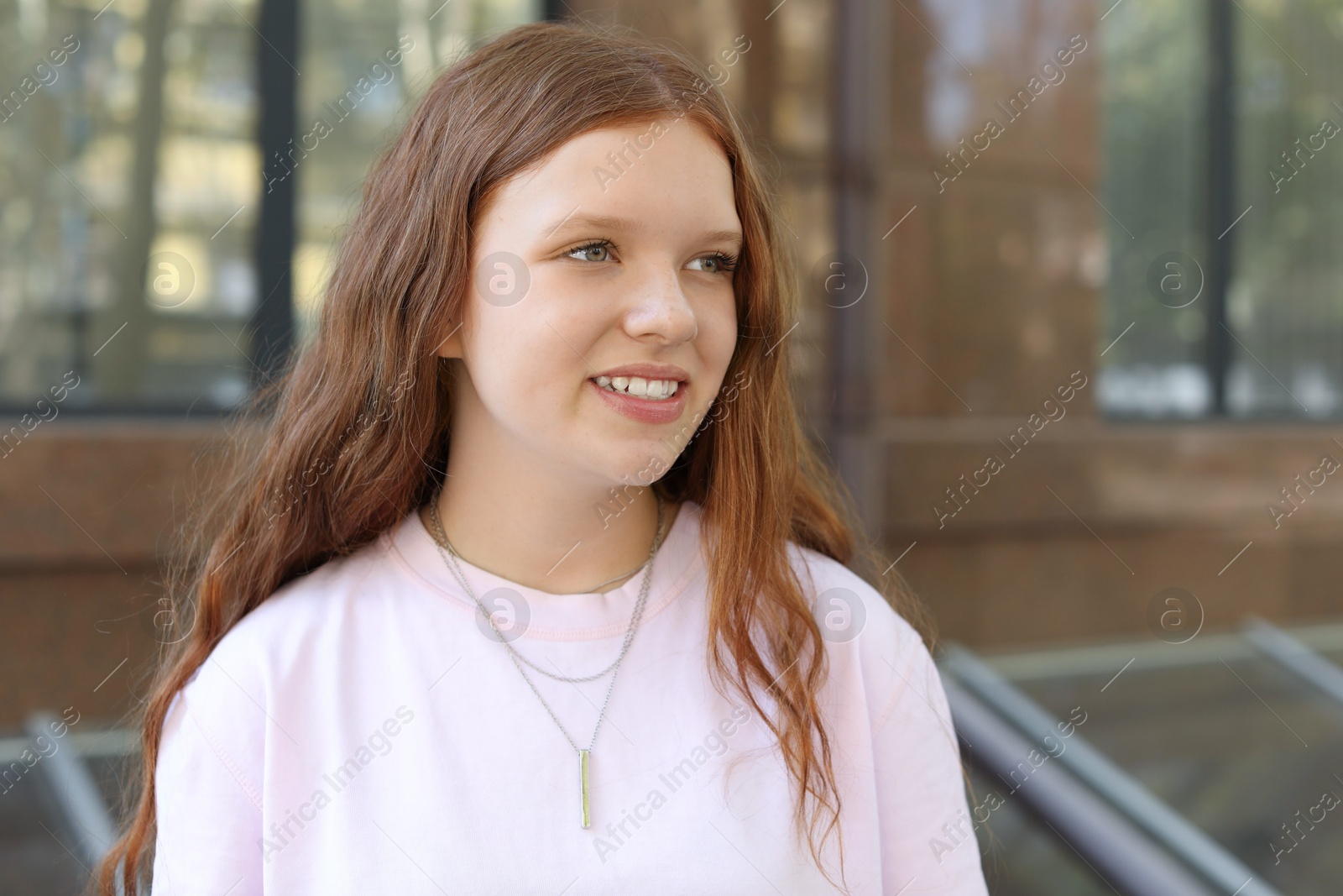 Photo of Portrait of happy teenage girl with long hair outdoors