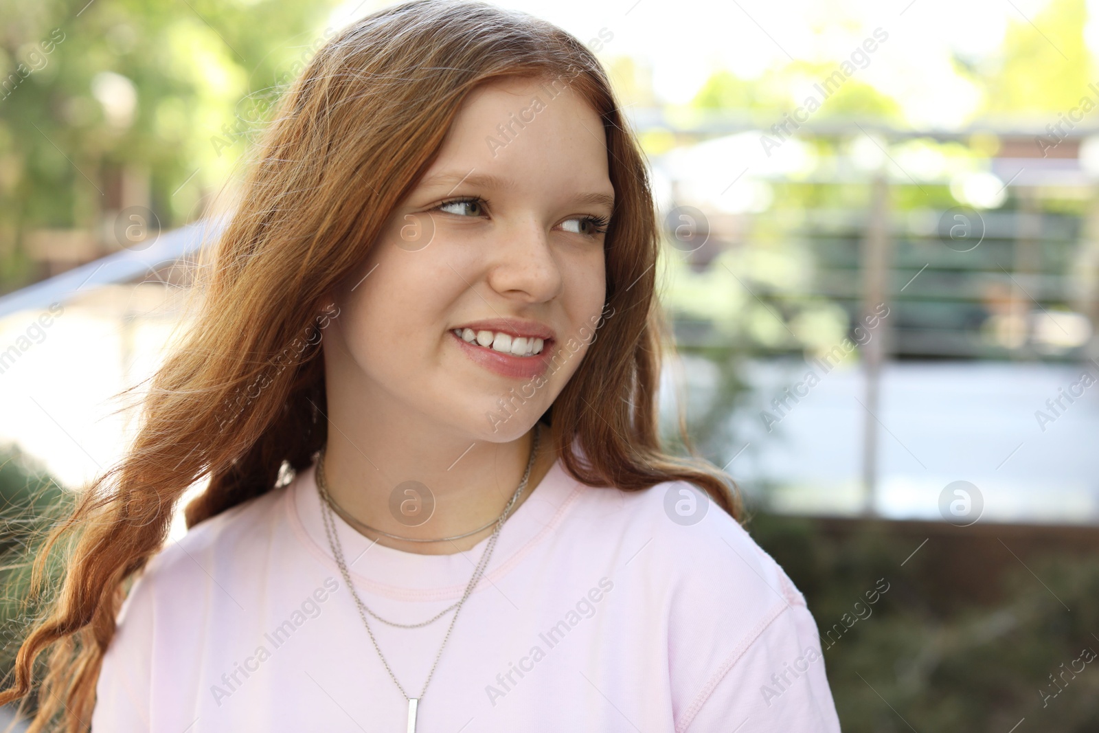 Photo of Portrait of happy teenage girl with long hair outdoors