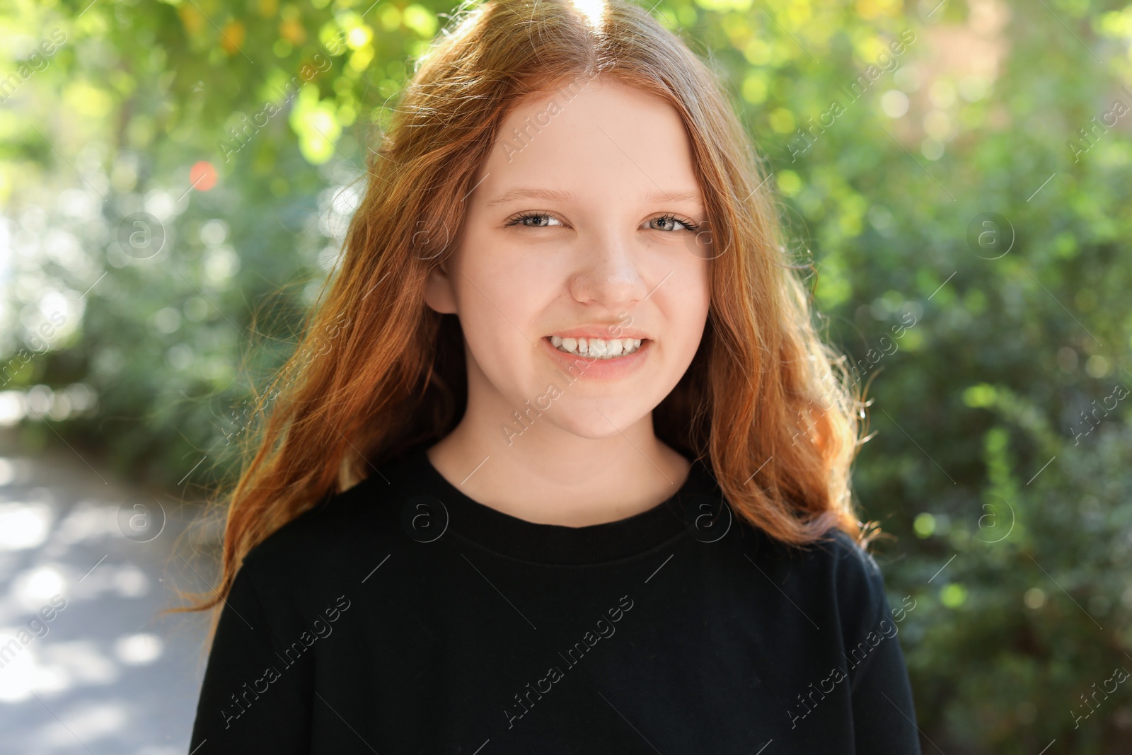 Photo of Portrait of happy teenage girl with long hair outdoors