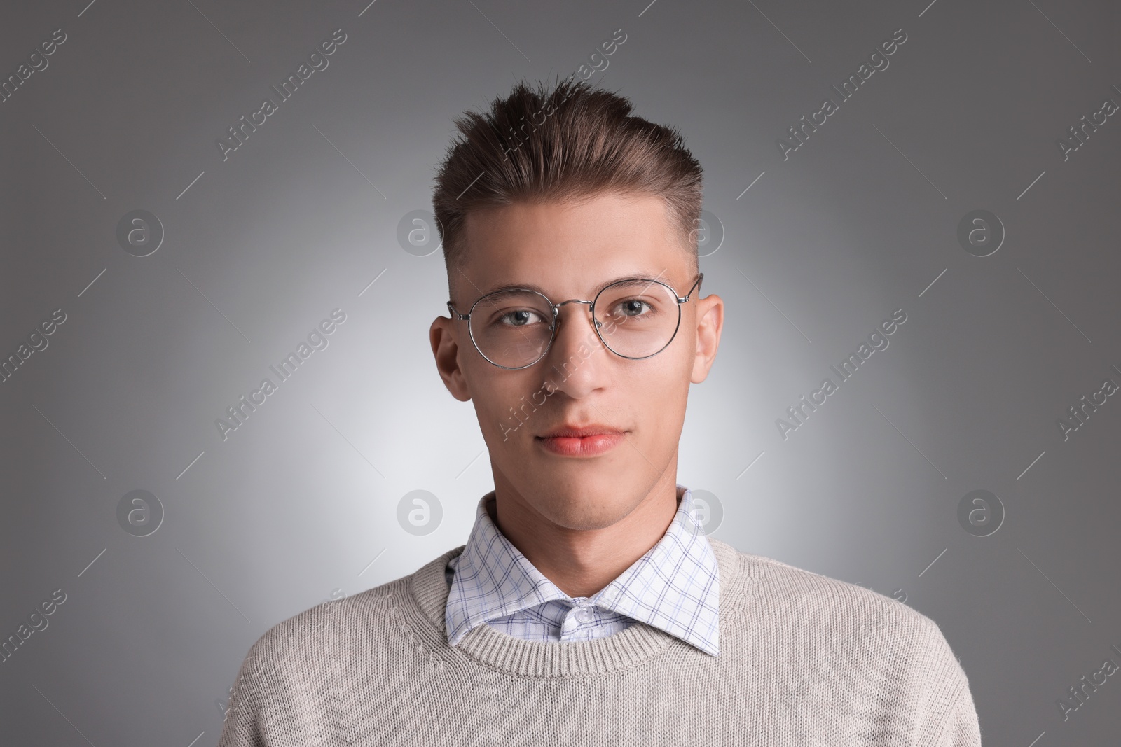 Photo of Handsome young man with stylish haircut on grey background