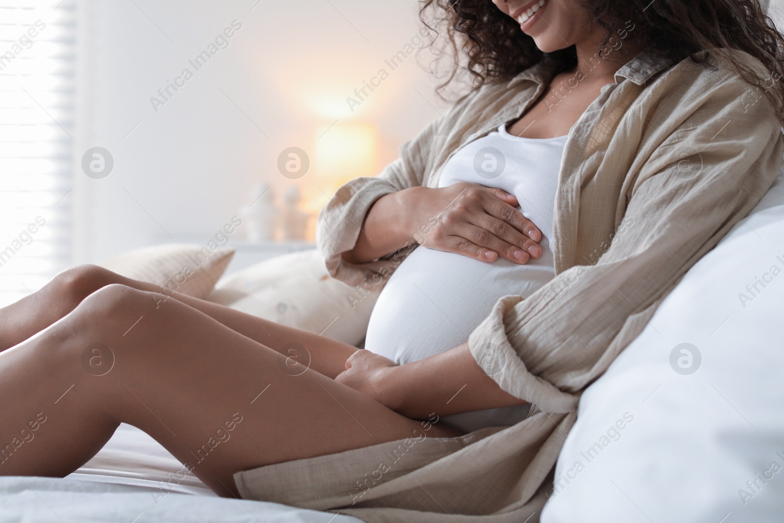 Photo of Pregnant woman on bed at home, closeup