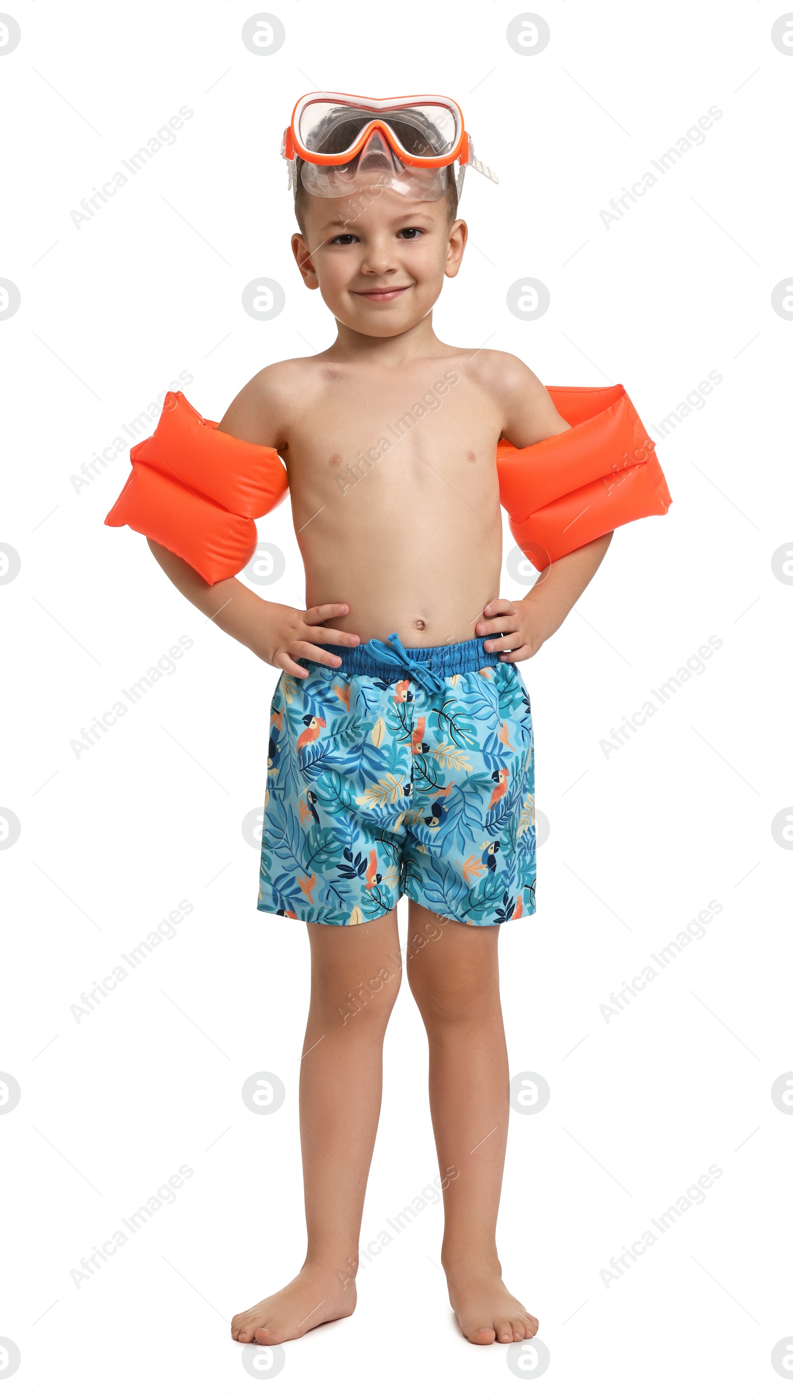 Photo of Cute little boy in beachwear with swim armbands and diving mask on white background