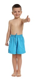 Photo of Cute little boy in beachwear showing thumbs up on white background