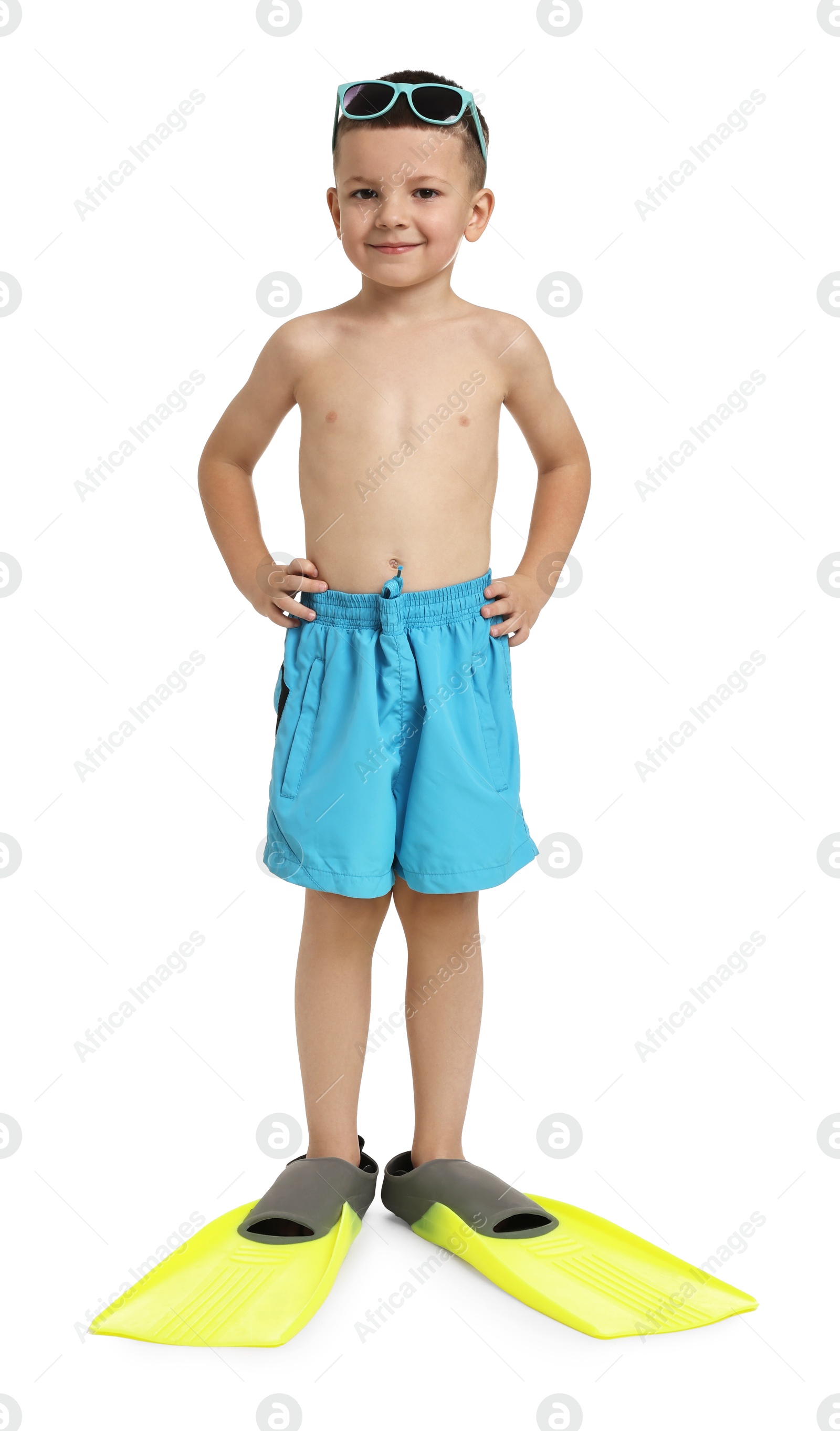 Photo of Cute little boy in beachwear with sunglasses and fins on white background