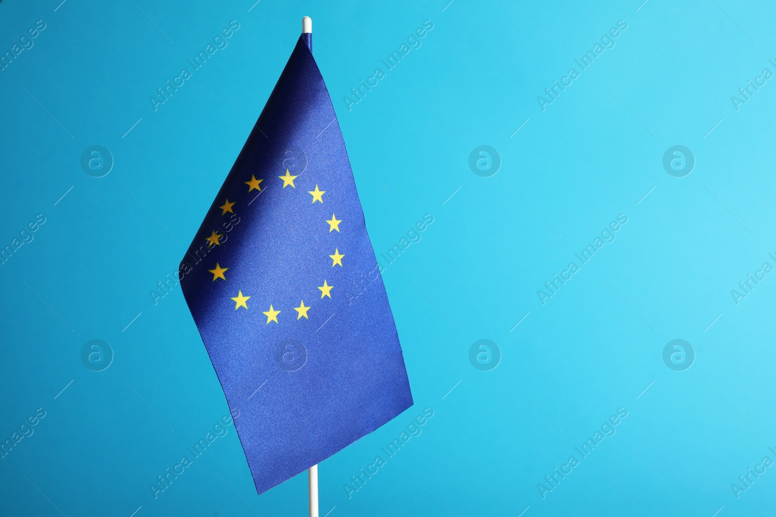 Photo of One flag of European Union on light blue background. Space for text