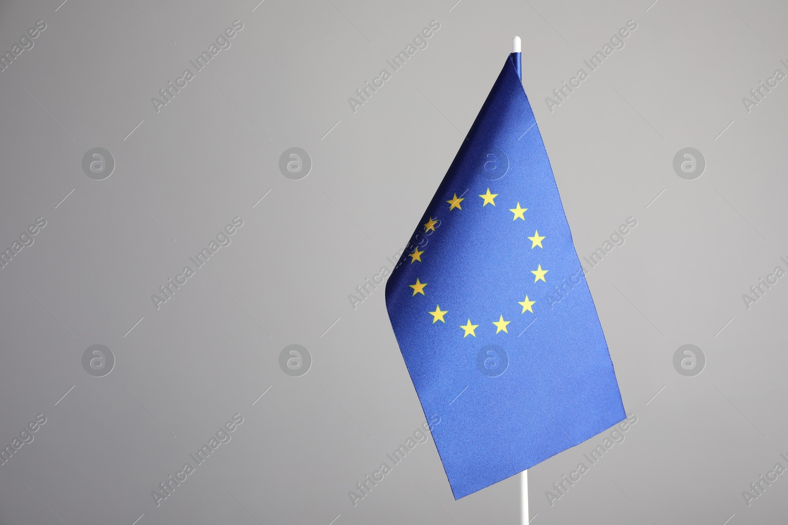 Photo of One flag of European Union on grey background. Space for text