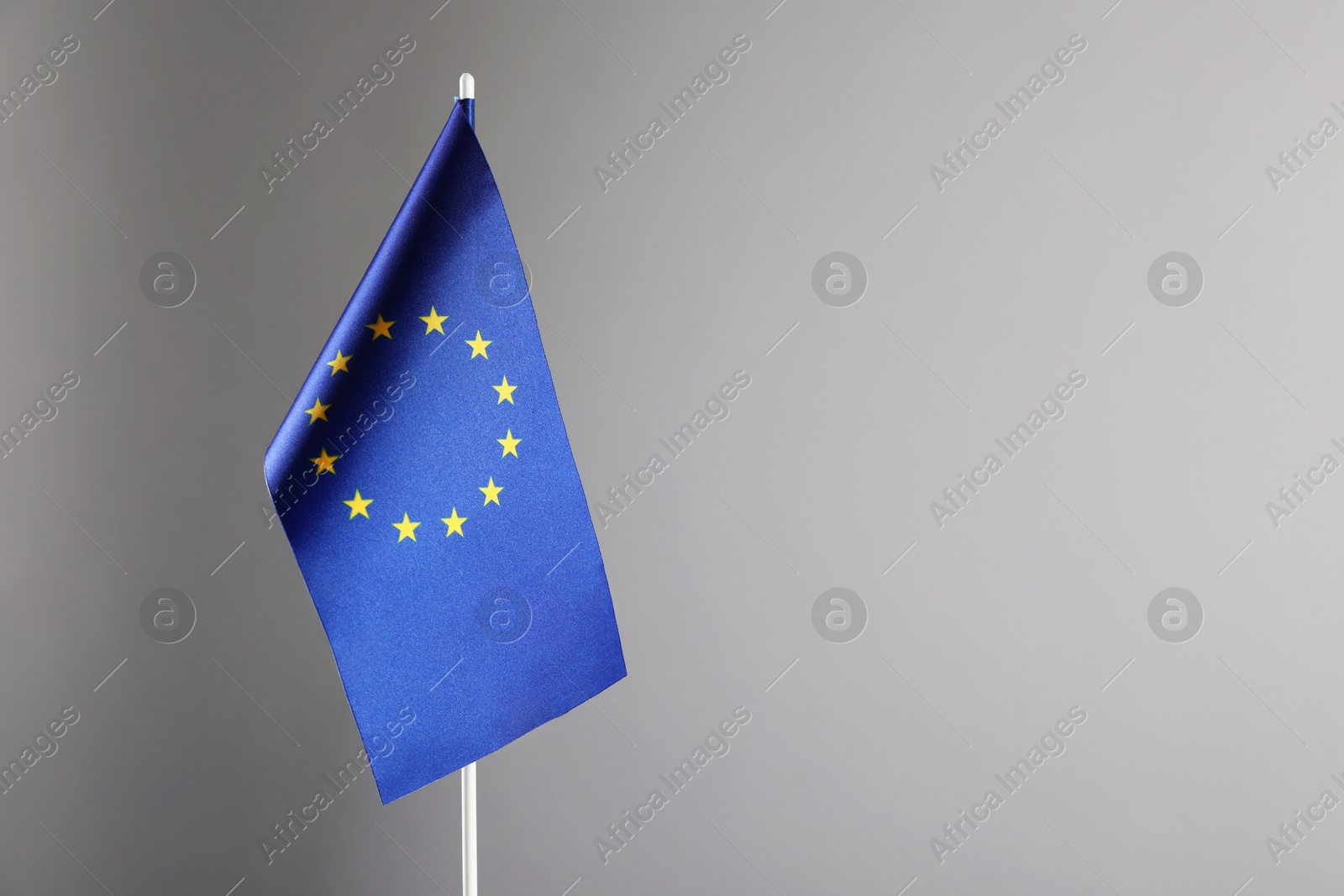 Photo of One flag of European Union on grey background. Space for text