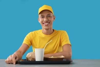 Fast-food worker with order at counter against light blue background