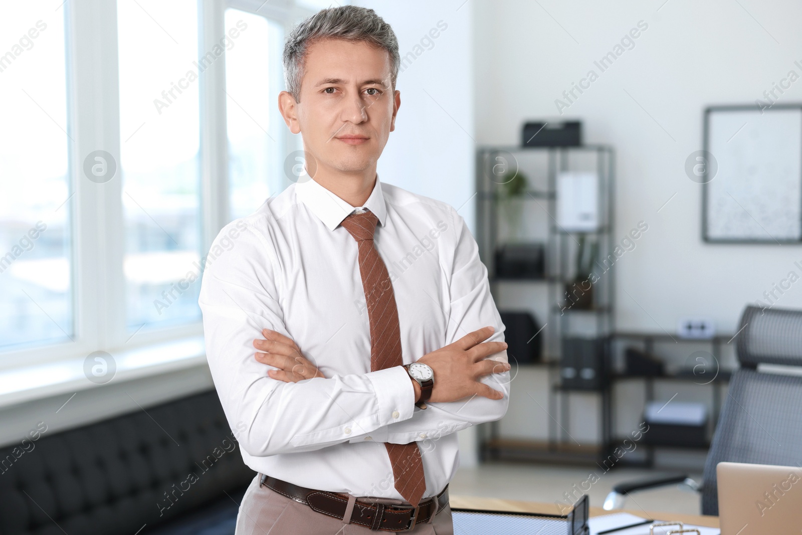 Photo of Portrait of middle aged man with crossed arms in office