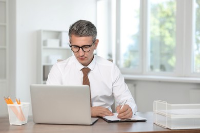 Middle aged man working at table in office