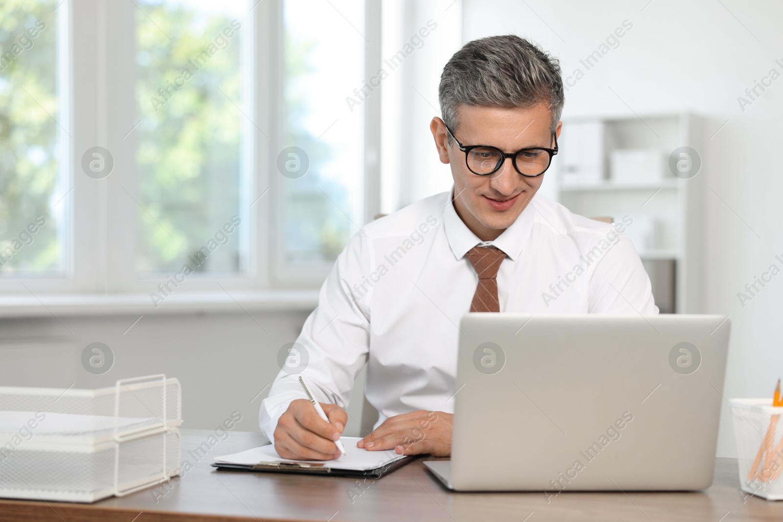 Photo of Middle aged man working at table in office