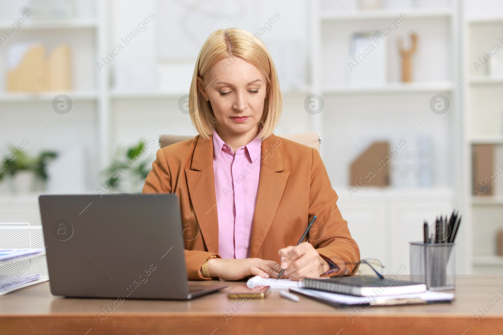 Photo of Middle aged woman working at table in office