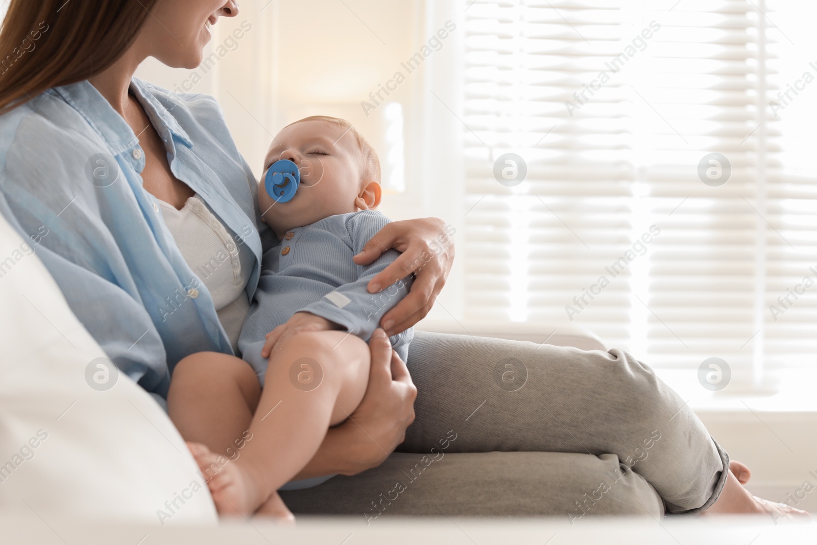 Photo of Mother with her sleeping baby on sofa indoors, closeup. Space for text