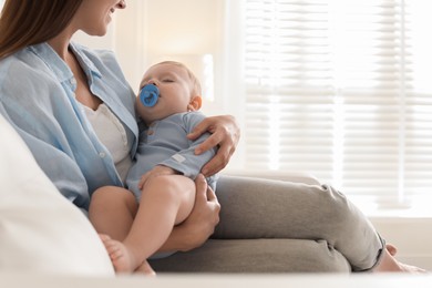 Photo of Mother with her sleeping baby on sofa indoors, closeup. Space for text