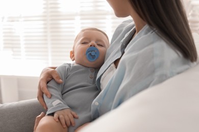 Photo of Mother with her sleeping baby on sofa indoors, closeup