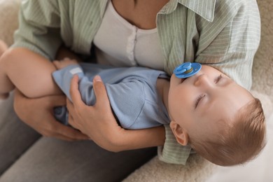 Photo of Mother with her sleeping baby in armchair, closeup