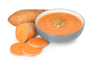 Photo of Delicious sweet potato soup with pumpkin seeds in bowl and fresh vegetables isolated on white