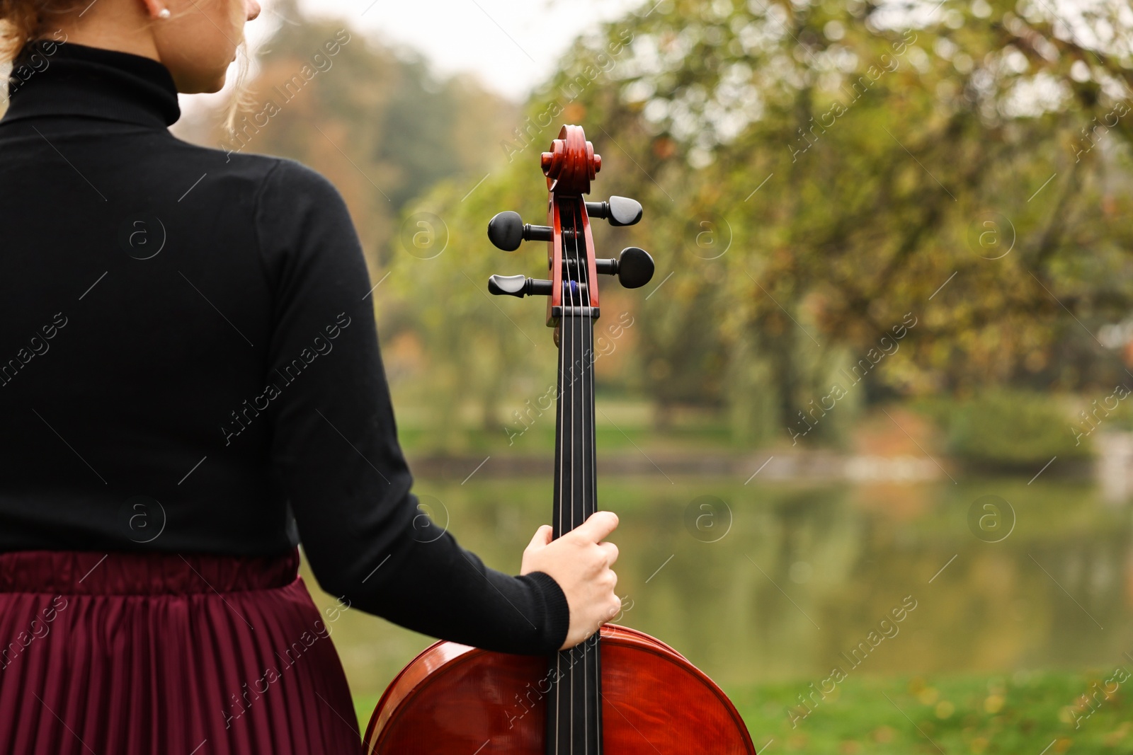 Photo of Young woman with cello in park, closeup. Space for text